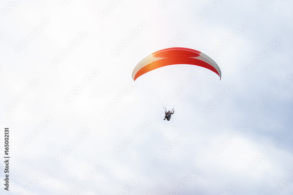 Paragliding in the sky. Paraglider flying over a mountain valley in summer sunny day. Paragliding in the sky. Paraglider flying over a mountain valley in summer sunny day.