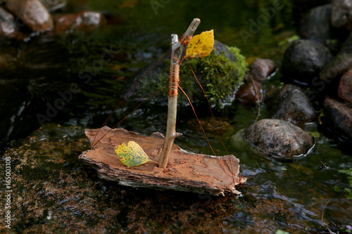 Handmade boats made from tree bark. Boats game in nature. Ships sailing on water surface.