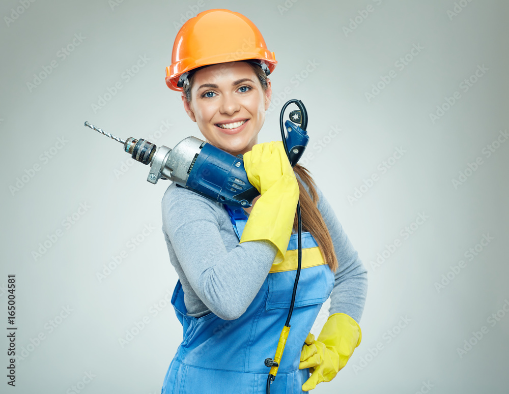 Woman builder holding drill tool.