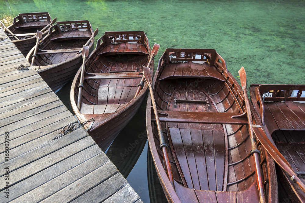 Wooden boats at the pier on the lake in the evening light. Wooden boats at the pier on the lake in the evening light.