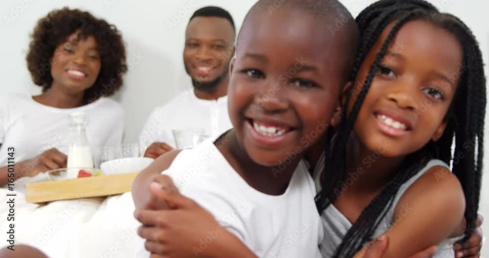 Children hugging each other on bed