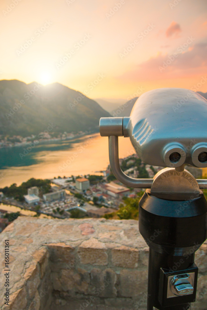 Coin Operated Binocular viewer in Kotor looking out to the Bay and city at sunset time in Montenegro