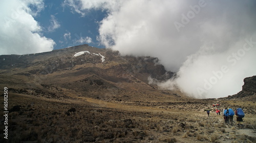 Kilimanjaro mountain, people on the mountain, backpack traveler. Porters in Kilimanjaro route caring alots of kilograms