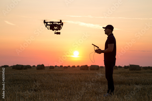Man operating a professional drone at sunset