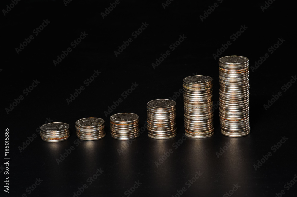 Piles of coins of different height on black background Piles of coins of different height on black background