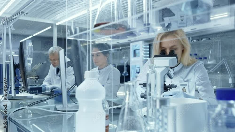 Team of Research Scientists Working with Microscope and Medical Data in a New High Tech Laboratory.  Shot on RED EPIC-W 8K Helium Cinema Camera.
