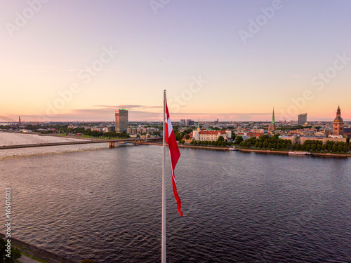 Beautiful aerial sunset view over Riga in Latvia with Huge Latvian flag in the foreground and river Daugava around the damb. photo