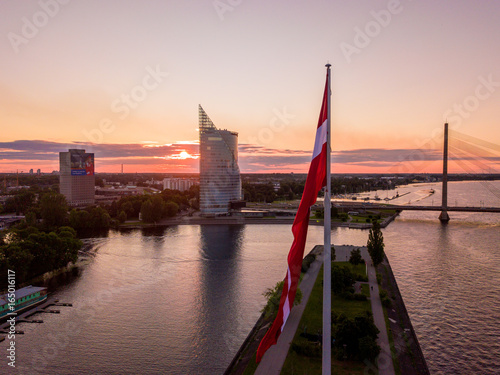 Beautiful aerial sunset view over Riga in Latvia with Huge Latvian flag in the foreground and river Daugava around the damb. photo