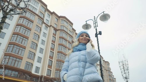 Cute woman talks on the phone at the urban street photo