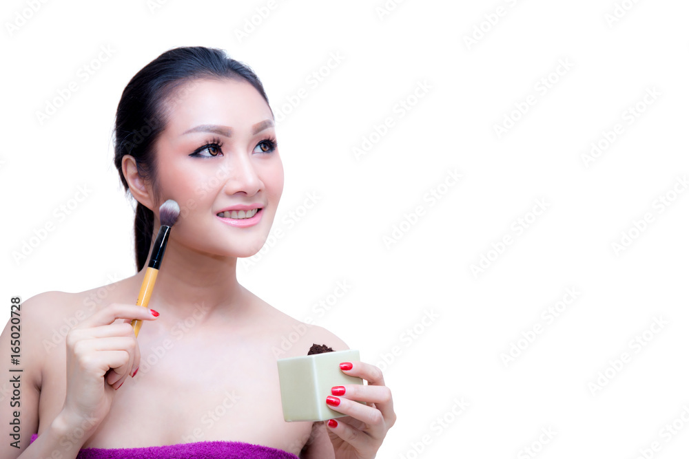 Closeup portrait of a asian woman applying dry cosmetic tonal foundation on the face using makeup brush, on pink background. Closeup portrait of a asian woman applying dry cosmetic tonal foundation on the face using makeup brush, on pink background.