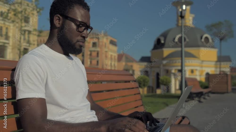 Side view on serious young entrepreneur working outdoors Side view on serious young entrepreneur working outdoors