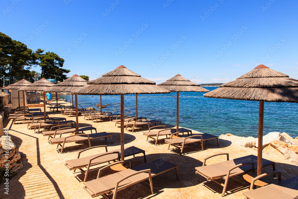Beach umbrellas in Saint Nicholas island in Porec, Istria. Croatia