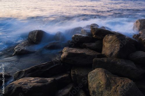Wave flowing over rocks with ethereal look.