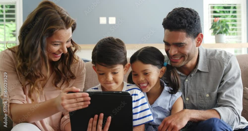 Happy family using digital tablet in living room Happy family using digital tablet in living room
