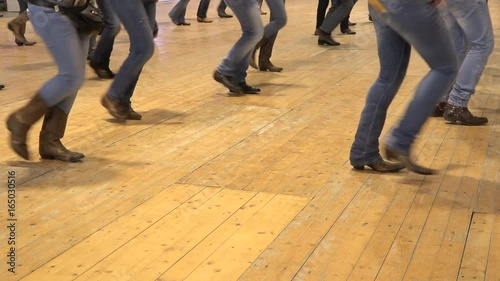People dancing country line dance at a folk event, cowboy USA style. Legs stepping choreography American horse festival. Music tradition jeans boots and flag