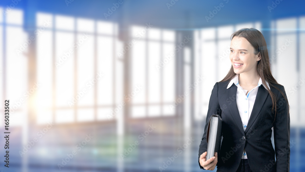 Young beautiful business woman and creative designer standing over blured interior background