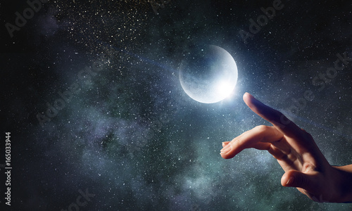 Hand touching the moon