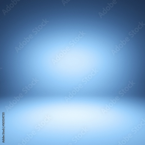 Blue spotlight background. Empty blue studio.