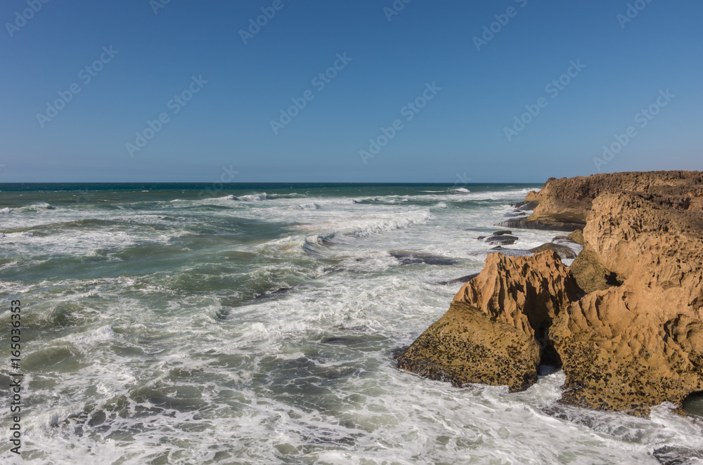 Waves breaking of cliffs near Oualidia lagoon in same name village in Atlantic ocean coast, Morocco Waves breaking of cliffs near Oualidia lagoon in same name village in Atlantic ocean coast, Morocco