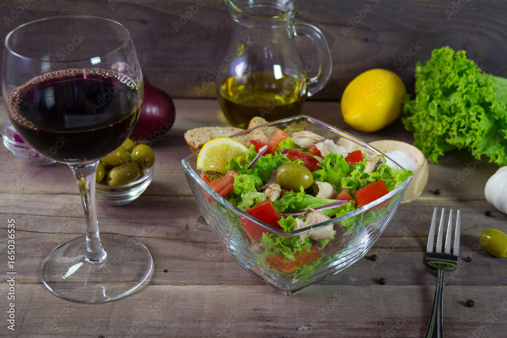 Light salad with mixed vegetables and tuna on a wooden table