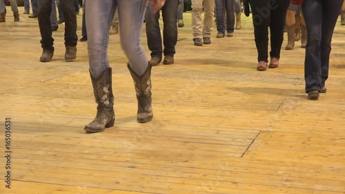 Woman legs dancing cowboy line dance at a folk country event, USA style. Female feet stepping at American horse festival. Music tradition jeans boots and flag