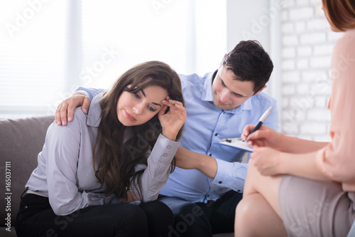 Man Consoling His Wife Sitting With Psychologist
