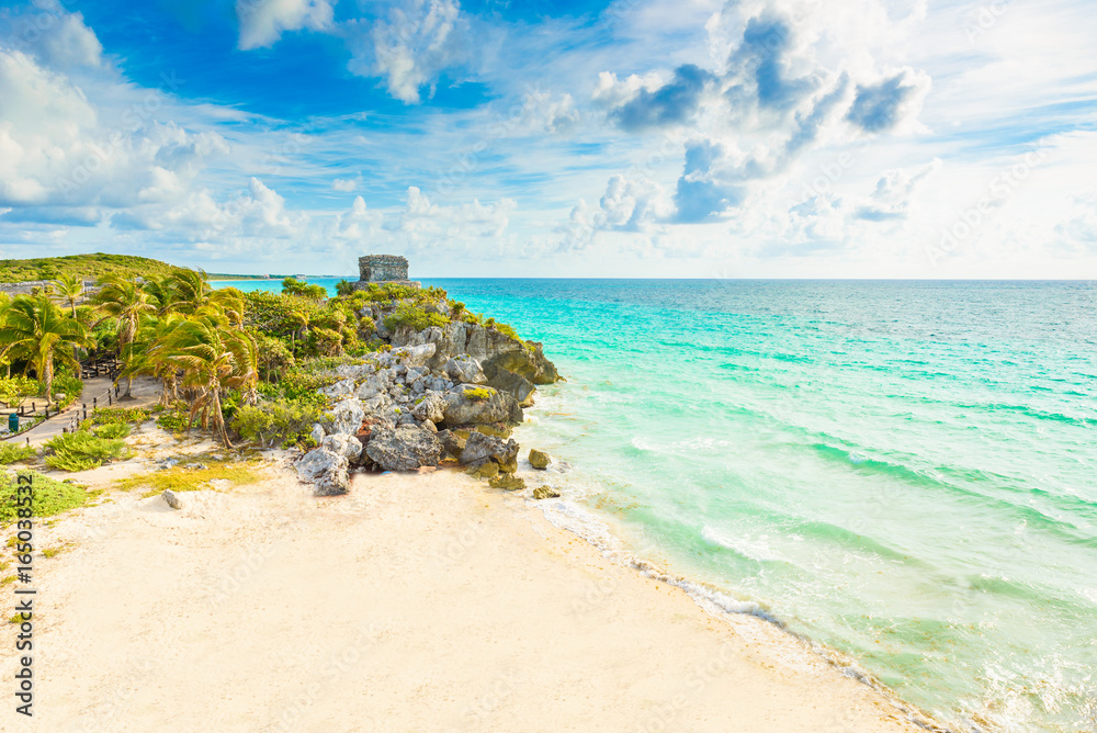 Fototapeta premium Mayan ruins of Tulum at tropical coast. God of Winds Temple at paradise beach. Mayan ruins of Tulum, Quintana Roo, Mexico.