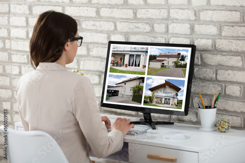 Businesswoman Looking At House Photos