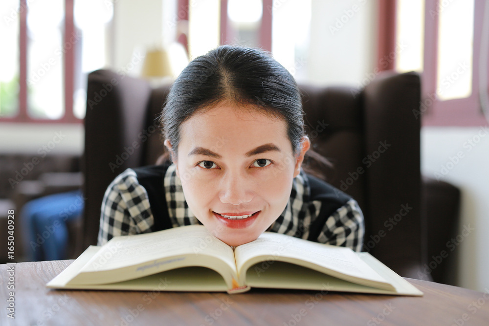 Young asian woman reading book in the library.
