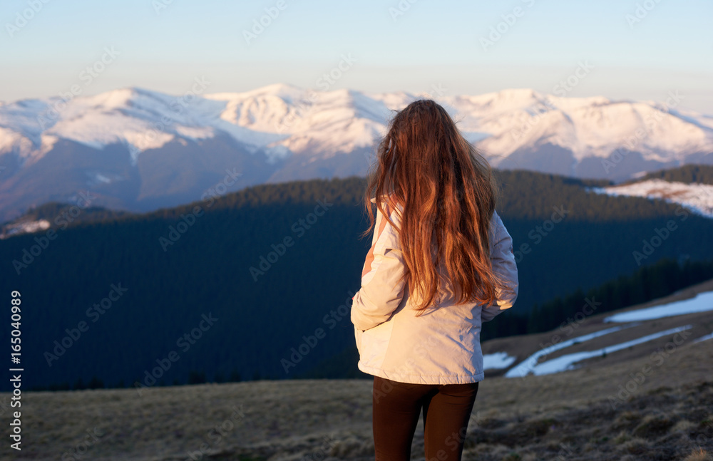 Rearview shot of a female hiker enjoying the view from the top of a mountain