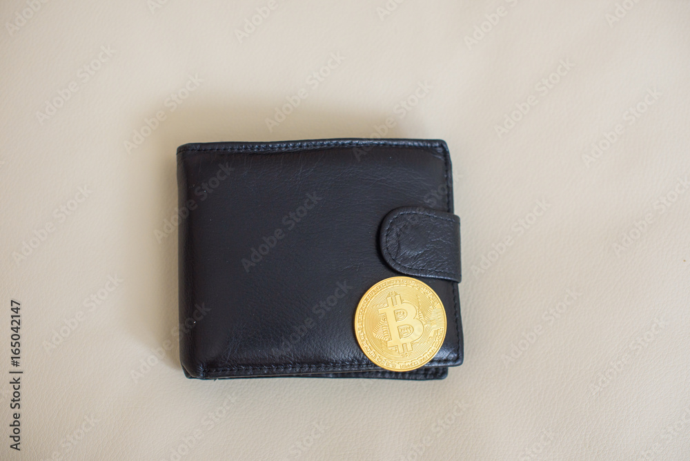 Golden bitcoin coin On a black leather wallet Golden bitcoin coin On a black leather wallet