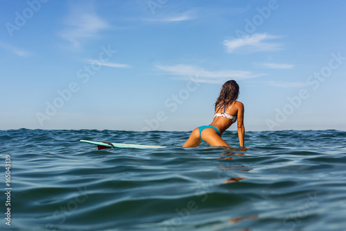Photography Beautiful sporty surfing girl in sexy bikini swimwear sit on big longboard surf surfboard board and make splashes on sunrise or sunset in the ocean