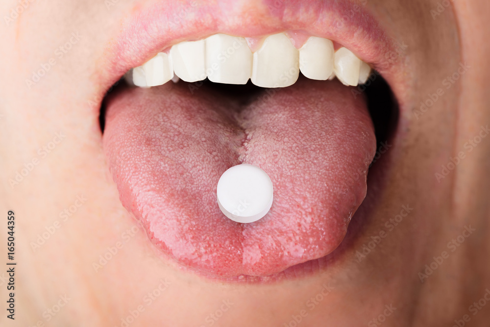 Obraz premium Man Showing Medicine On Tongue