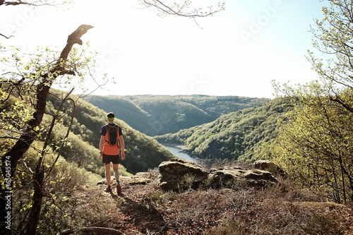 Coureur de trail qui fait une pause au dessus d'une rivière