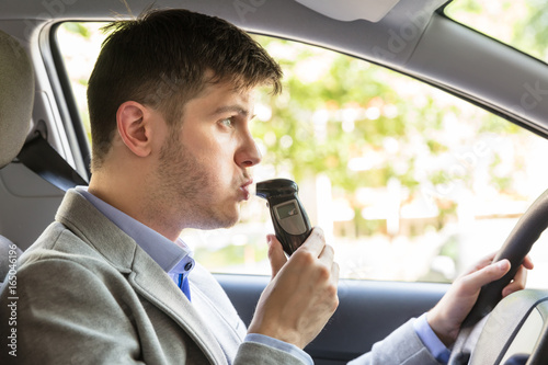 Man Sitting Inside Car Taking Alcohol Test