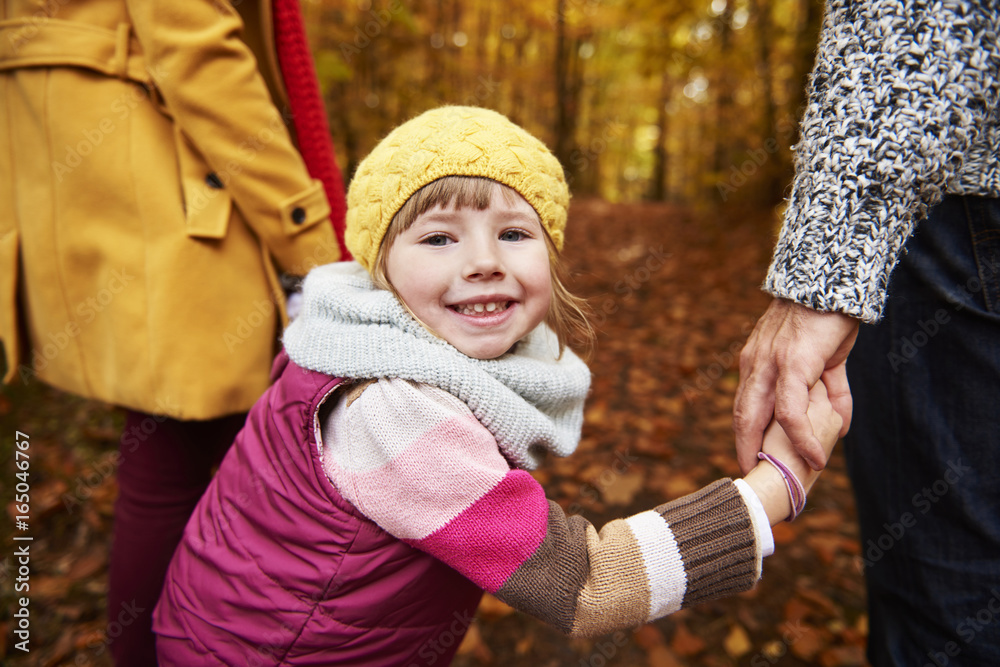 Smiley girl holding parents hands Smiley girl holding parents hands