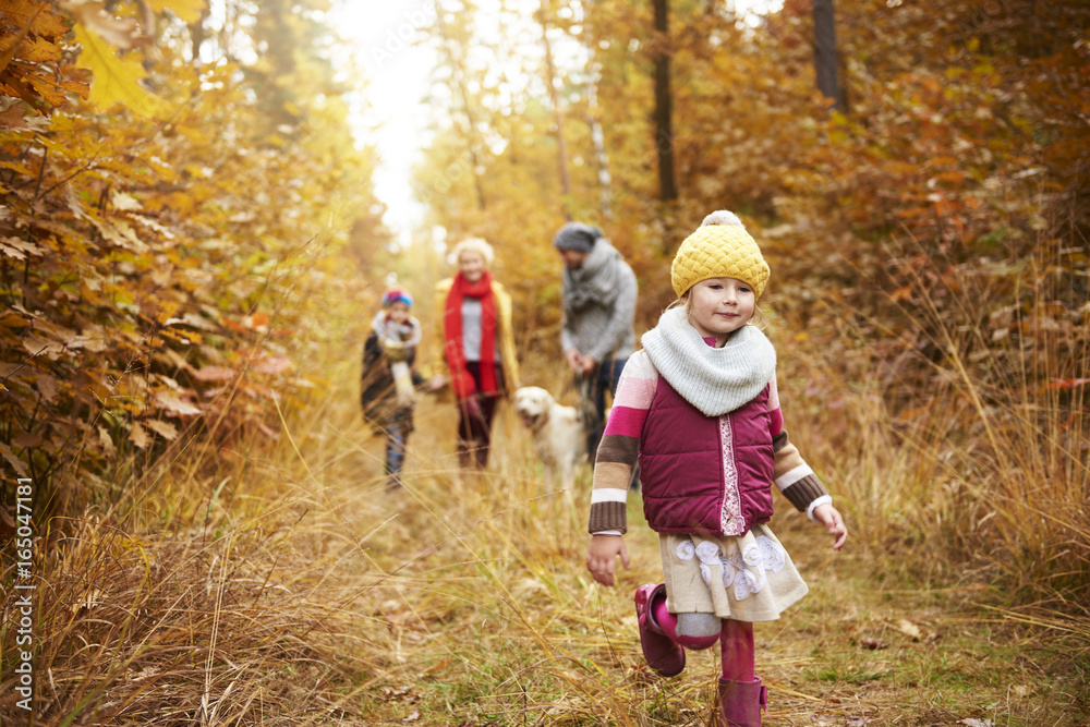 Walking girl and family in the background Walking girl and family in the background
