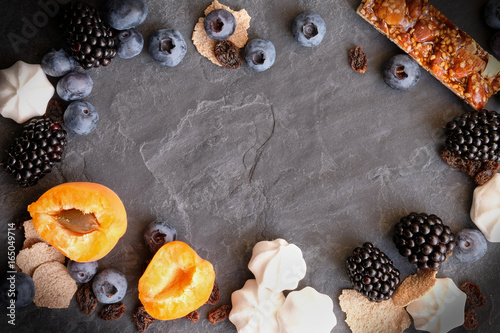 Berries of strawberries, blueberries, blueberries, blackberries and apricots with a pear on the background of slate