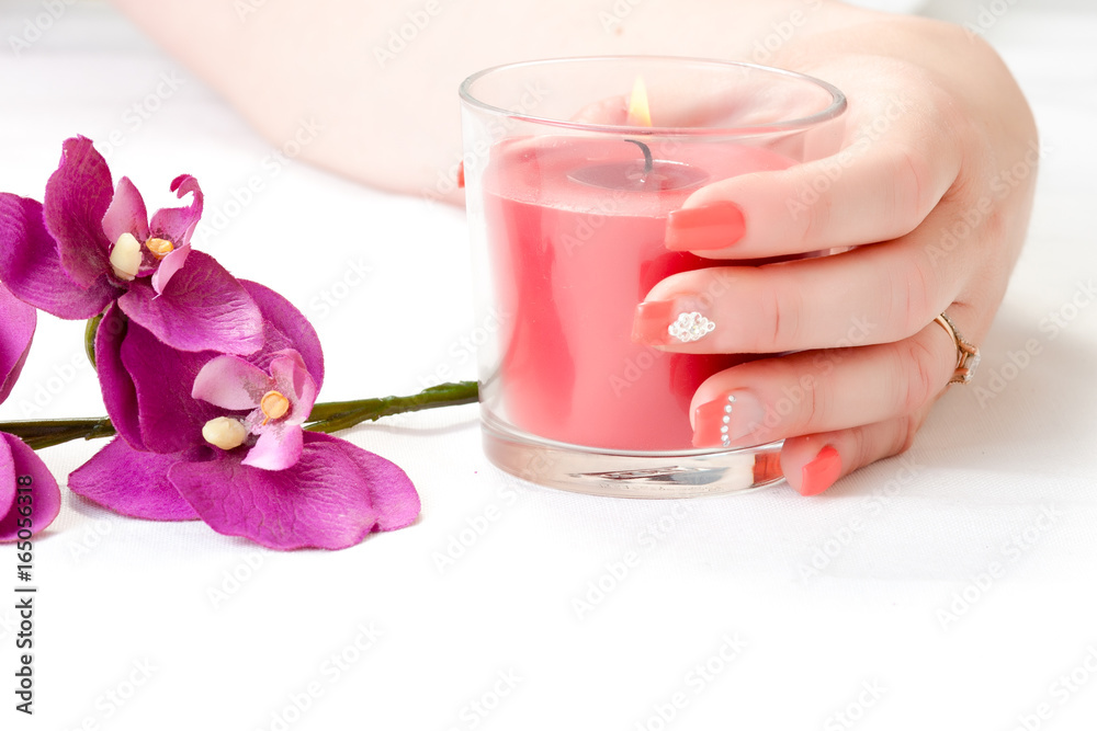 female hands with orchid petals, candle and nail art female hands with orchid petals, candle and nail art