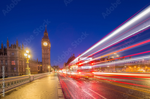 London, England - Big Ben and Houses of Parliament taken from the middle of Westminster Bridge at dusk with the lights of cars and buses passing by