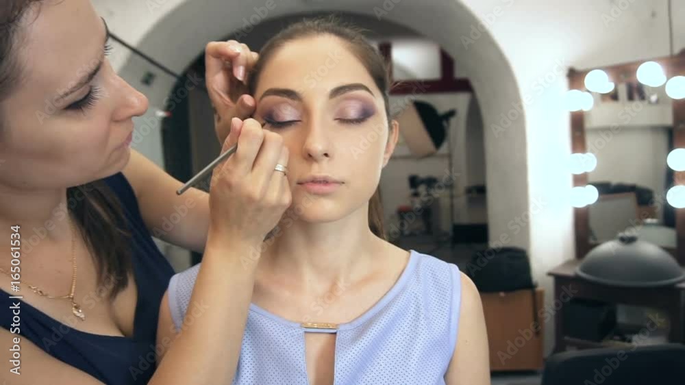 Young beautiful woman applying make-up by make-up artist Young beautiful woman applying make-up by make-up artist