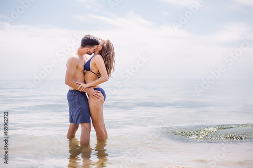 Sexy couple at sea,slim body,long hair,swimwear,swimsuit,beautiful tan,summer holidays concept,make up,bearded man
