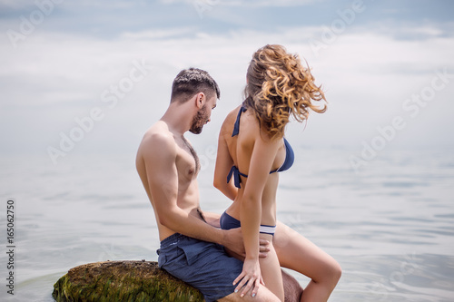 Sexy couple at sea,slim body,long hair,swimwear,swimsuit,beautiful tan,summer holidays concept,make up,bearded man