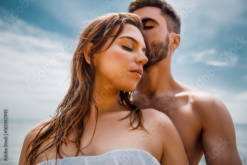 Sexy couple at sea,slim body,long hair,swimwear,swimsuit,beautiful tan,summer holidays concept,make up,bearded man