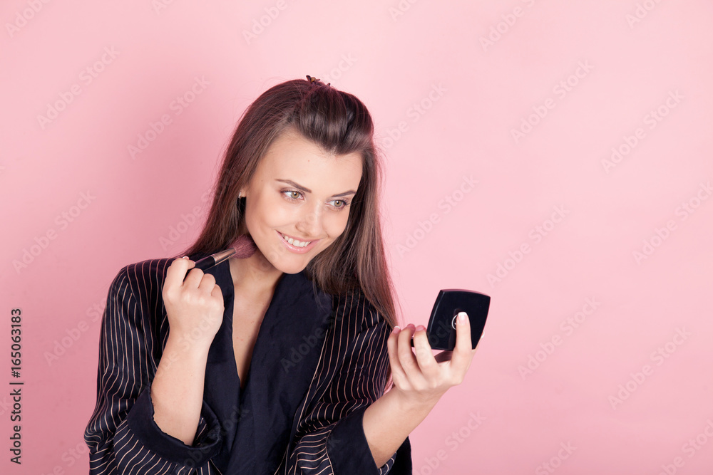 girl in coat makes brush makeup looks in the mirror girl in coat makes brush makeup looks in the mirror