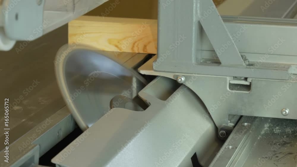 Circular saw cuts a wooden beam at an angle of 45 degrees.