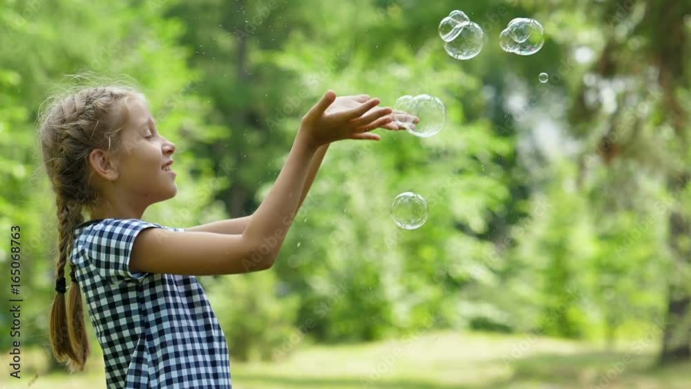 Little girls playing with soap bubbles outdoor. Slow motion.
Little girls playing with soap bubbles outdoor. Slow motion.