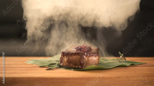 chef cooks food in the kitchen. finishing meal teasty beef steak with salad for guest of restaurant. final serving of dish. young expert cook beef fillet gourmet. Fry steak meat. closeup. slow motion photo