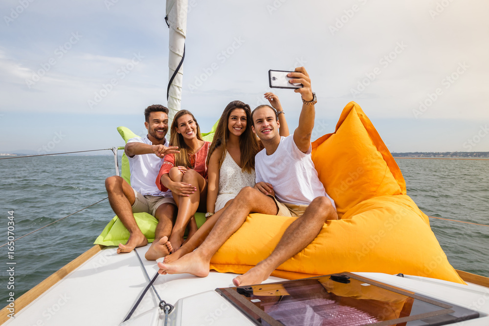 Obraz premium Group of friends having fun in boat in river