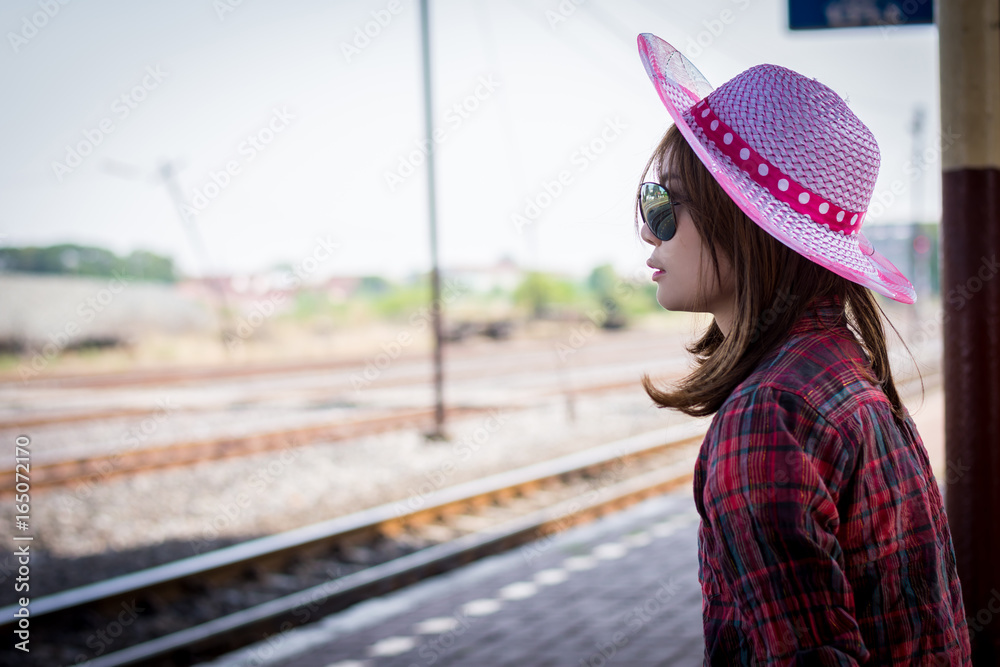 Girl tourist sitting on a bench in a train station.